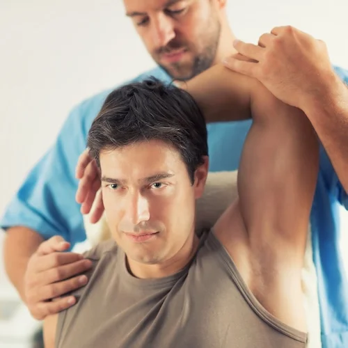 Physiotherapists Cochrane working with Patient Arm for Pain Relief