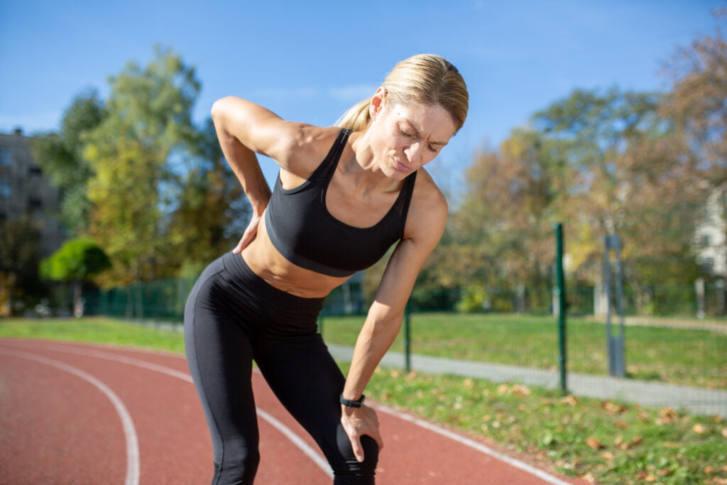 A women getting strain on her back after a high intensity run