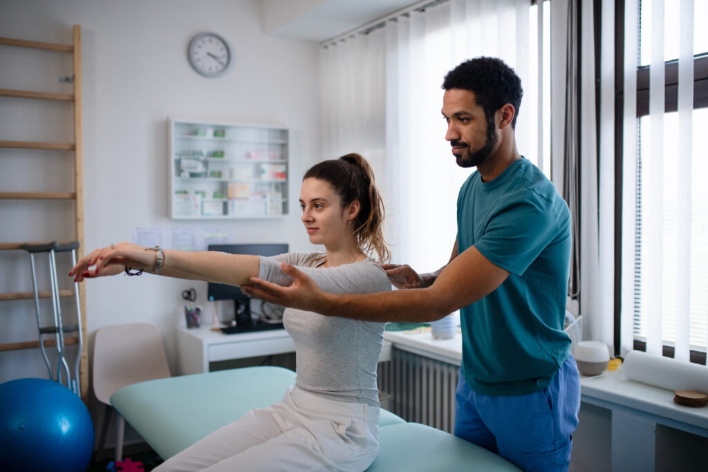 Physiotherapist helping client to increase mobility